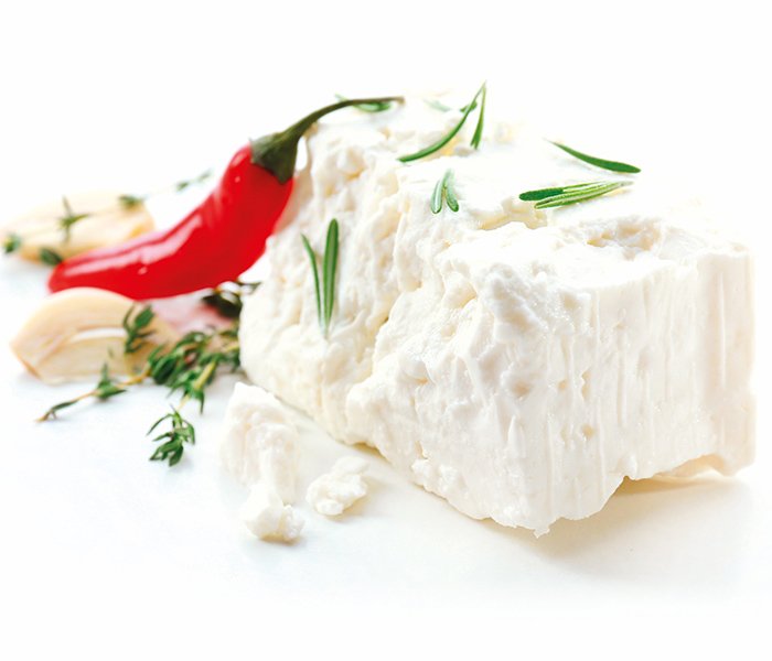 A piece of feta cheese with a red chili and herbs